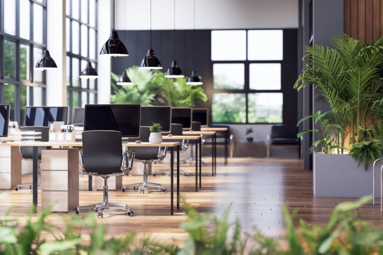 A bright modern office with floor-to-ceiling windows, hanging plants, and wood textures.